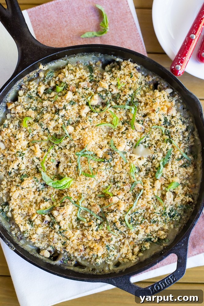 Close-up of perfectly baked Vegan Scalloped Potatoes with a golden-brown crispy pesto breadcrumb topping, ready to serve.