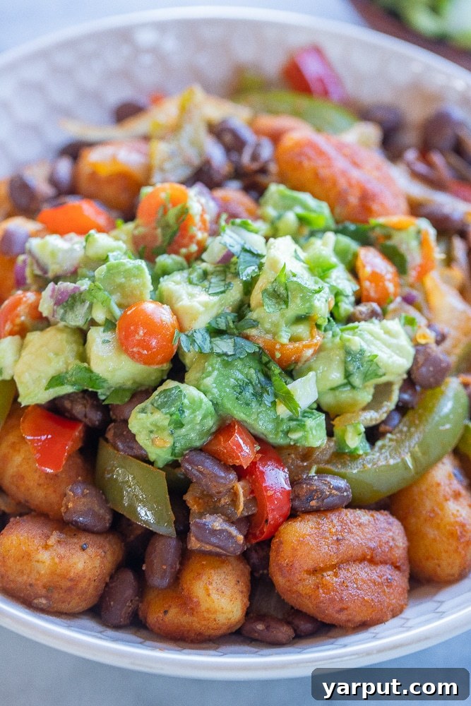 Fiesta Gnocchi Skillet with Fresh Avocado Salsa 7 Close-up of a serving of Fajita Gnocchi Skillet, showcasing the texture of the gnocchi and the fresh avocado salsa topping.
