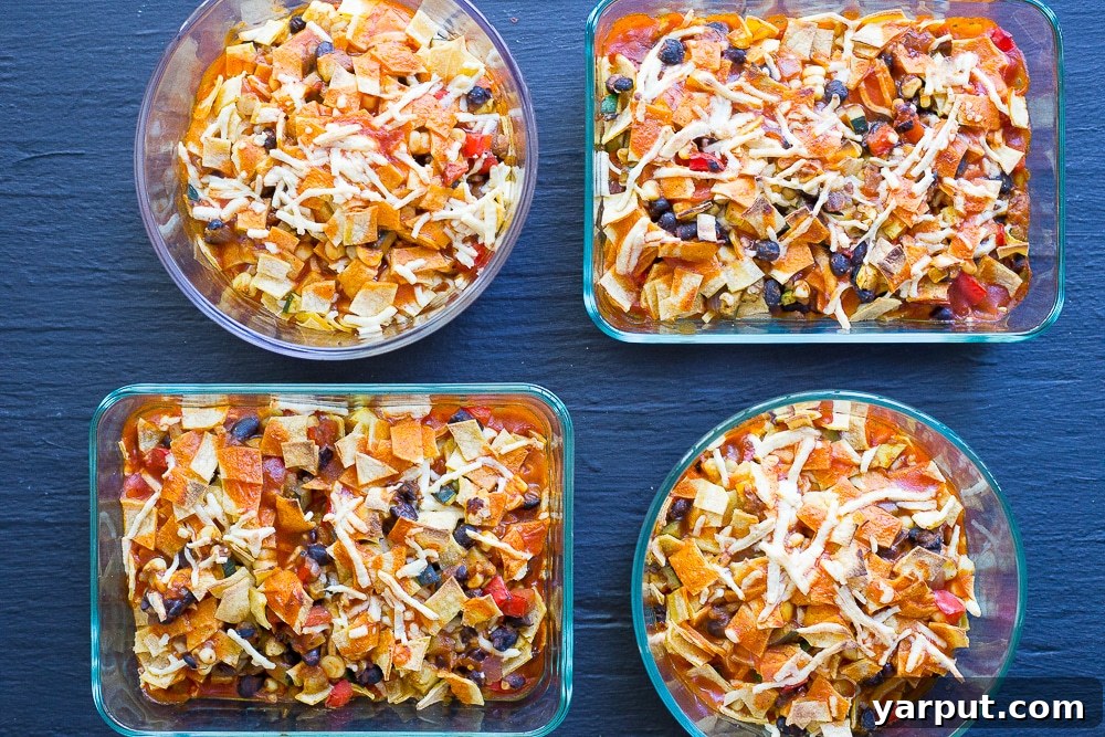 Enchilada filling cooked in a skillet with black beans and spices, ready to be assembled into individual meal prep bowls.