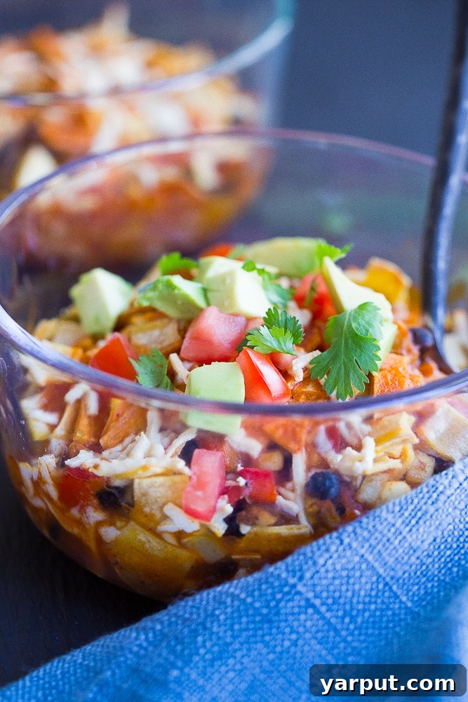 A perfectly baked individual enchilada lunch bowl, hot from the oven with melted cheese and bubbling sauce, ready for meal prep.