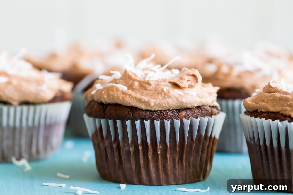 Decadent Vegan Gluten-Free Chocolate Coconut Cupcakes with Silky Chocolate Whipped Cream 5 A tray of freshly baked Chocolate Coconut Cupcakes, beautifully frosted with Chocolate Whipped Cream and shredded coconut.