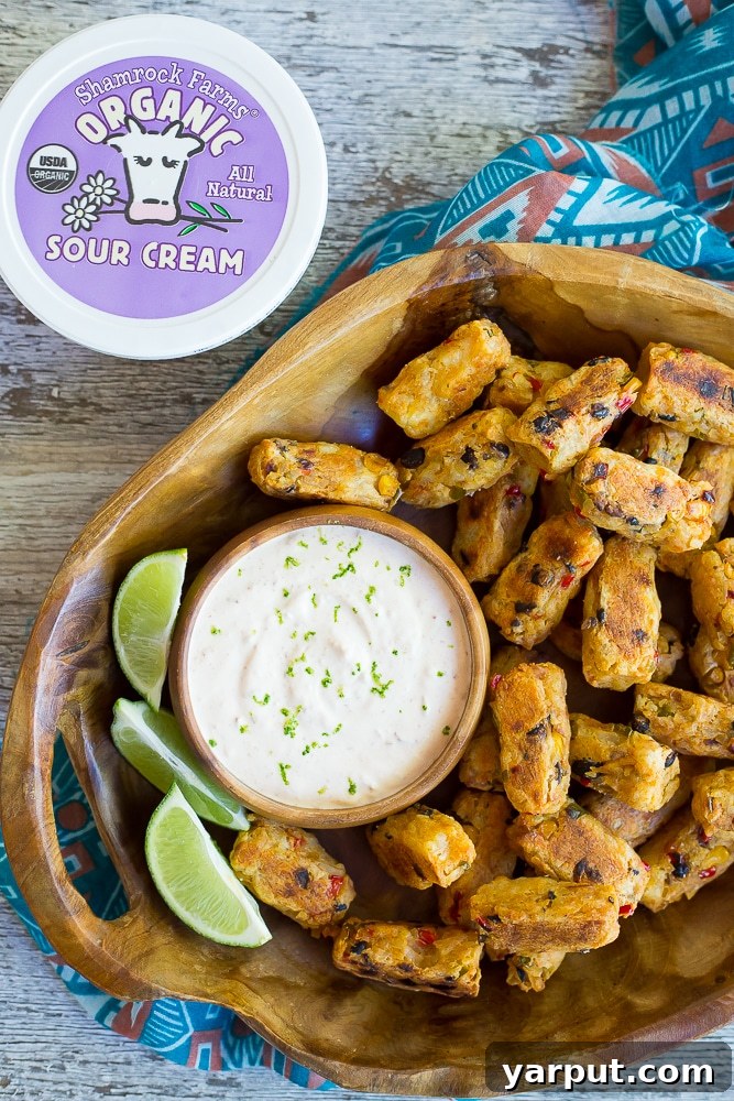 Southwest Potato Bites with Creamy Chipotle Lime Dip 6 A top-down view of a platter filled with golden Tex-Mex Tater Tots, beautifully arranged around a central bowl of creamy Chipotle Lime Dip, ready for sharing.