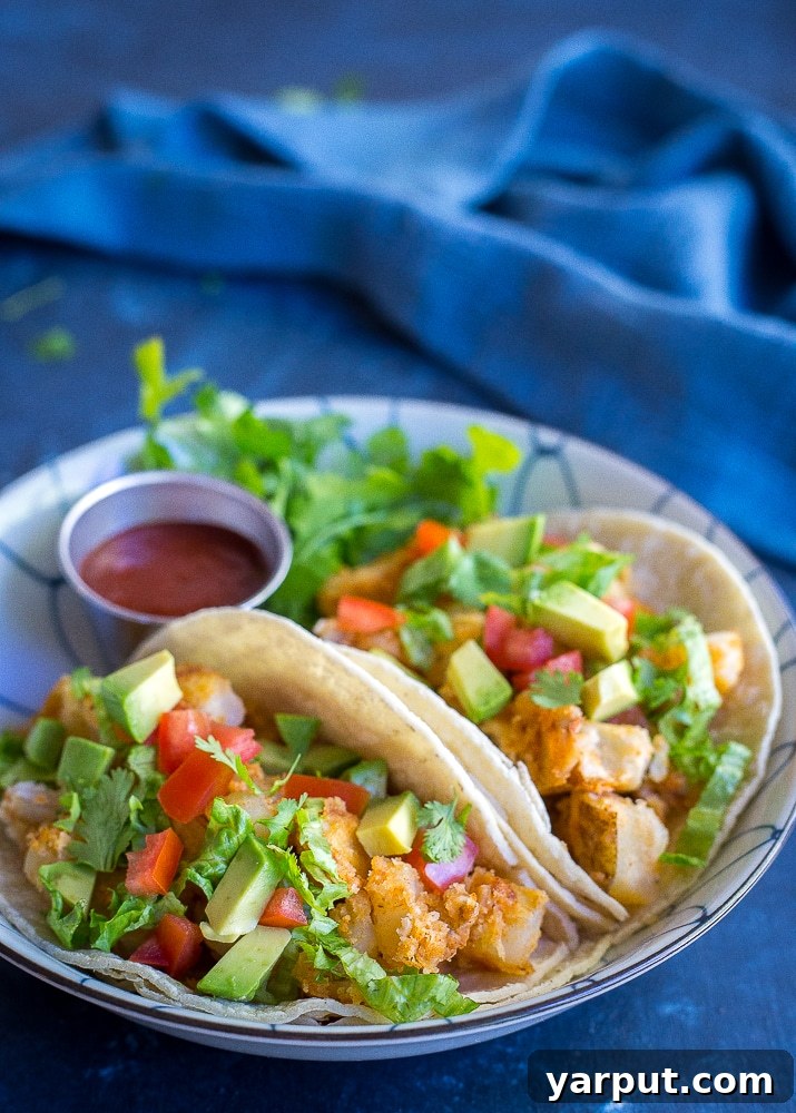 Golden Crunch Potato Tacos 2 Delicious Crispy Potato Tacos ready to be served, garnished with fresh cilantro and lime wedges.