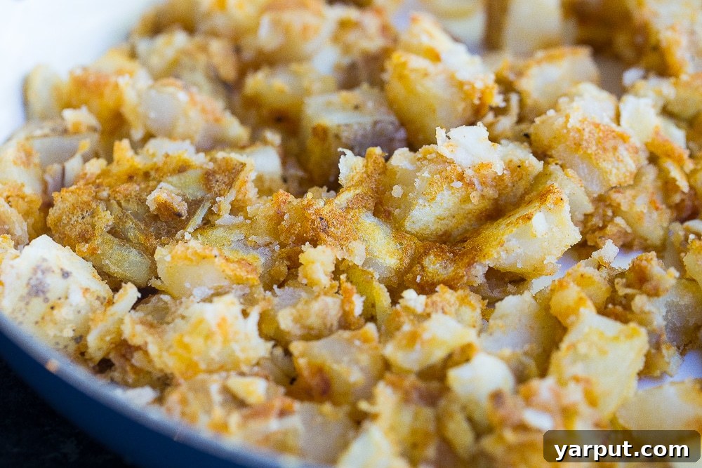 Golden Crunch Potato Tacos 3 Crispy spiced potato filling for tacos in a skillet, showcasing golden-brown texture.