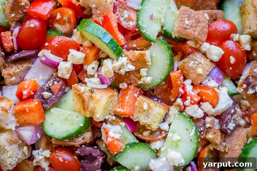 Vibrant Greek Panzanella 4 Close-up of Easy Greek Panzanella Salad, showcasing toasted bread, colorful veggies, feta, and olives, coated in a fresh vinaigrette.