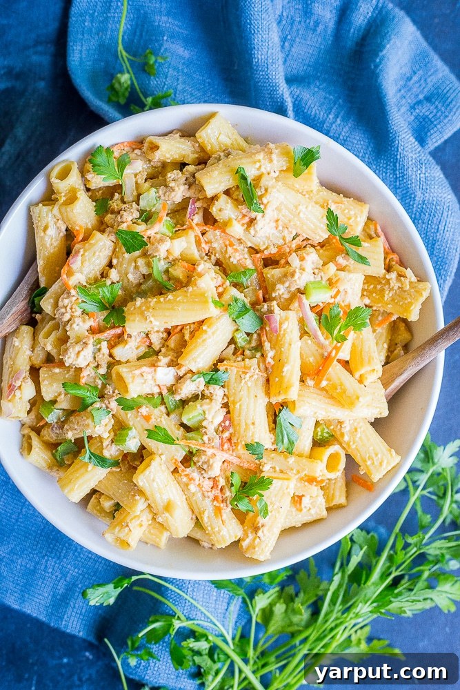 Plant-Based Tuna Pasta Salad 5 Close up of Vegan Tuna Pasta Salad with fresh parsley garnish, showing creamy texture and visible pieces of tofu and vegetables.