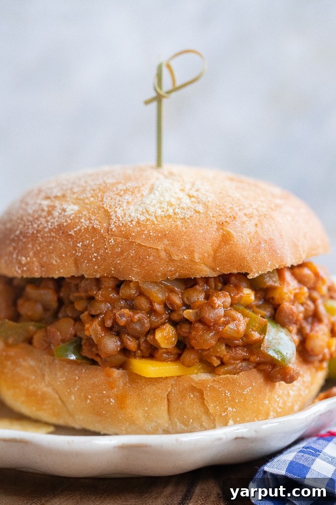 Ultimate Lentil Sloppy Joes 7 A delicious vegetarian sloppy joe sandwich on a plate with a decorative toothpick, ready to be enjoyed as a hearty, plant-based meal.