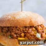 A vegetarian sloppy joe on a plate with a toothpick, ready to be served.