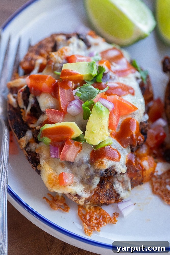 Hearty Black Bean Sweet Potato Bake 6 A close-up of a perfectly cheesy roasted sweet potato, overflowing with black beans and melted cheese, showcasing its mouth-watering appeal.