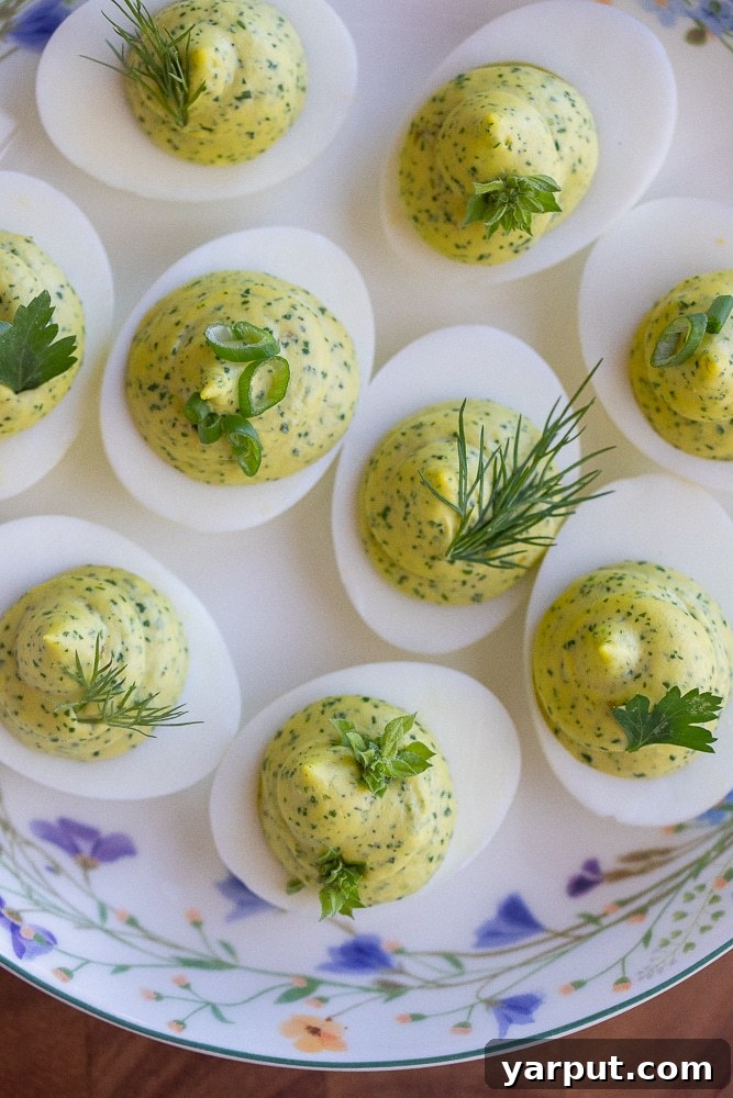 Herbal Ambrosia Deviled Eggs 5 A close-up view of a platter filled with beautifully arranged Green Goddess Deviled Eggs, showcasing their vibrant green filling and ready for serving at a party.