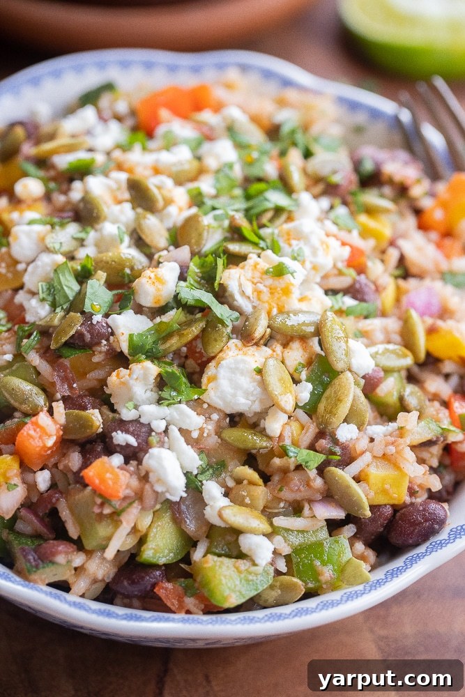 Close up of a bowl of meal prep bean and rice salad with smoked paprika dressing