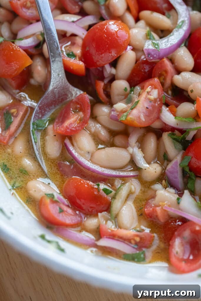 Cherry Tomato and White Bean Salad with Basil Vinaigrette 7 close up of a spoonful of white bean tomato salad with dressing