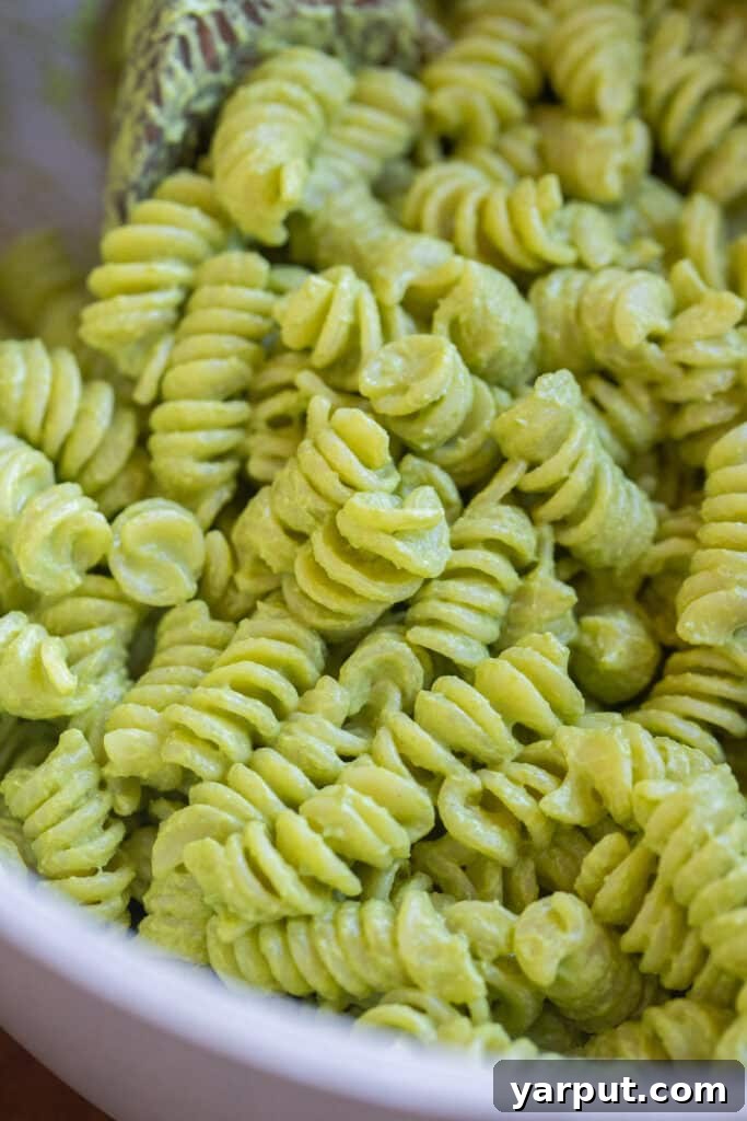 Close up of a pot of creamy pesto pasta