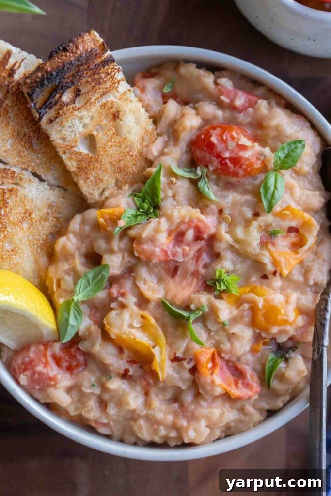 Creamy White Beans with Roasted Cherry Tomatoes 51 close up of a bowl of refried white beans with cherry tomatoes and toast