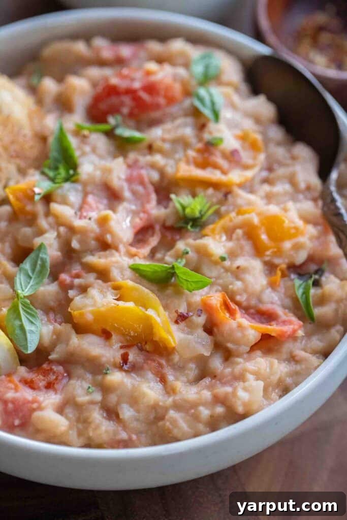 Creamy White Beans with Roasted Cherry Tomatoes 6 Close up of a bowl of mashed great northern beans with basil and tomatoes