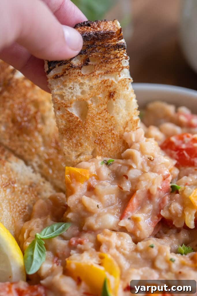 Creamy White Beans with Roasted Cherry Tomatoes 7 a slice of toast dipped into the smashed white beans