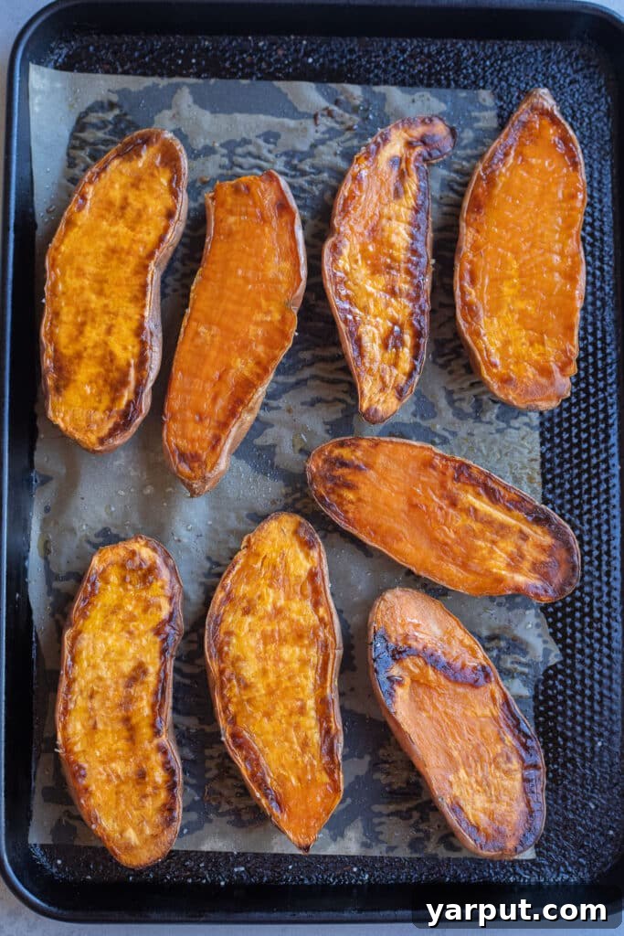 Roasted sweet potato halves on a baking sheet