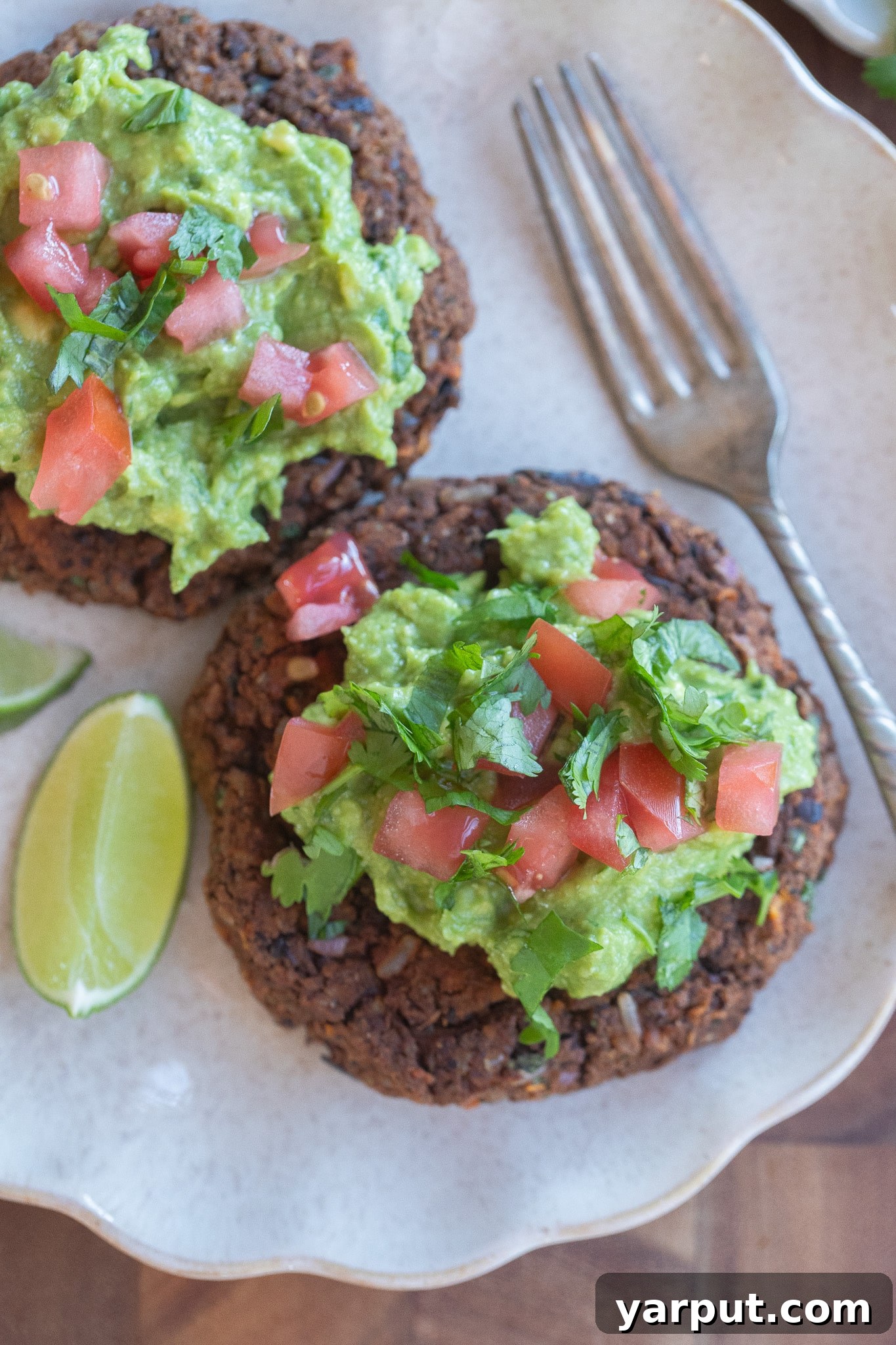 Crispy Black Bean and Sweet Potato Patties 6 two black bean patties on a plate topped with guacamole