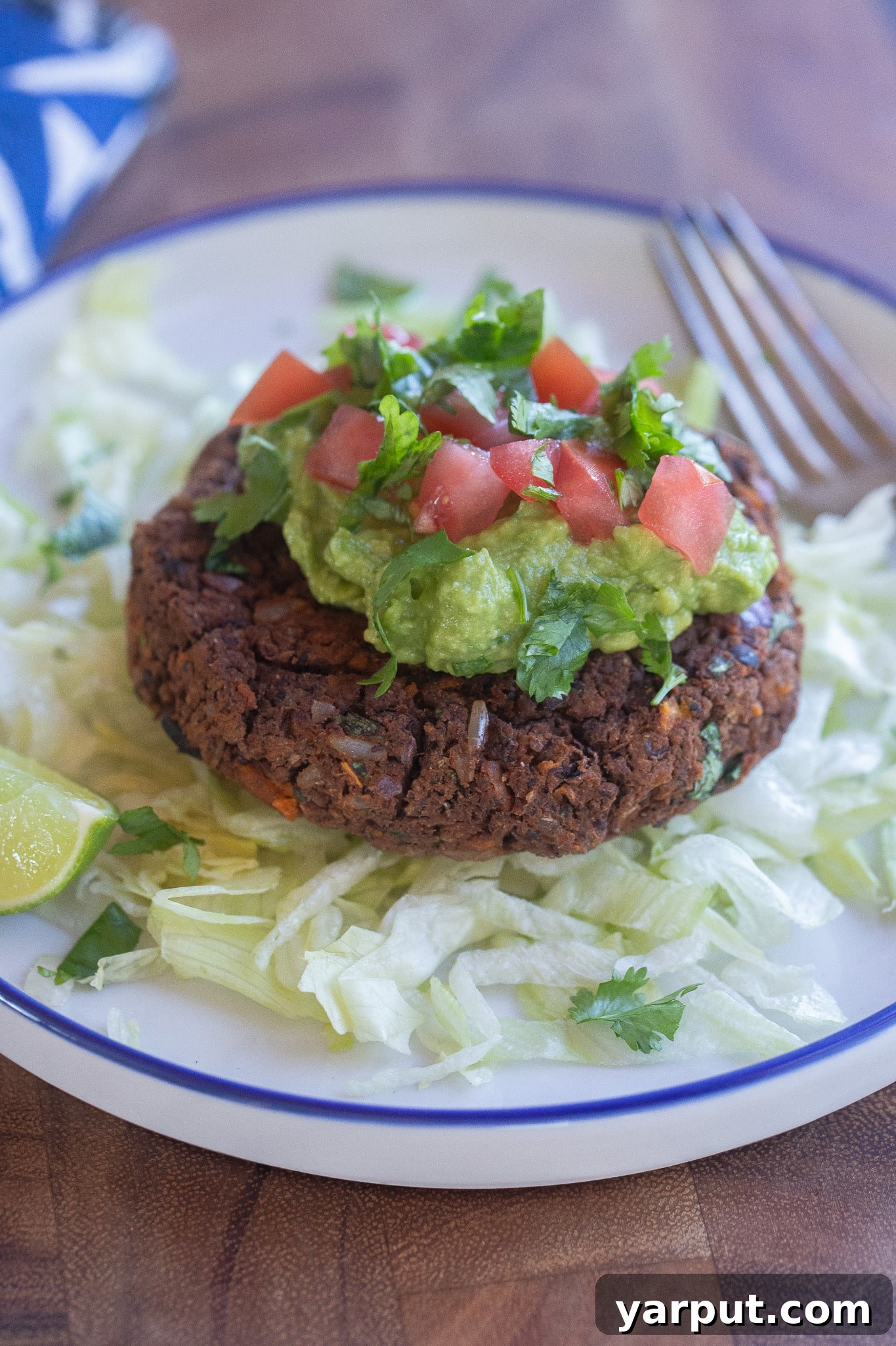 Crispy Black Bean and Sweet Potato Patties 7 gluten free black bean patty on a plate with lettuce and guacamole