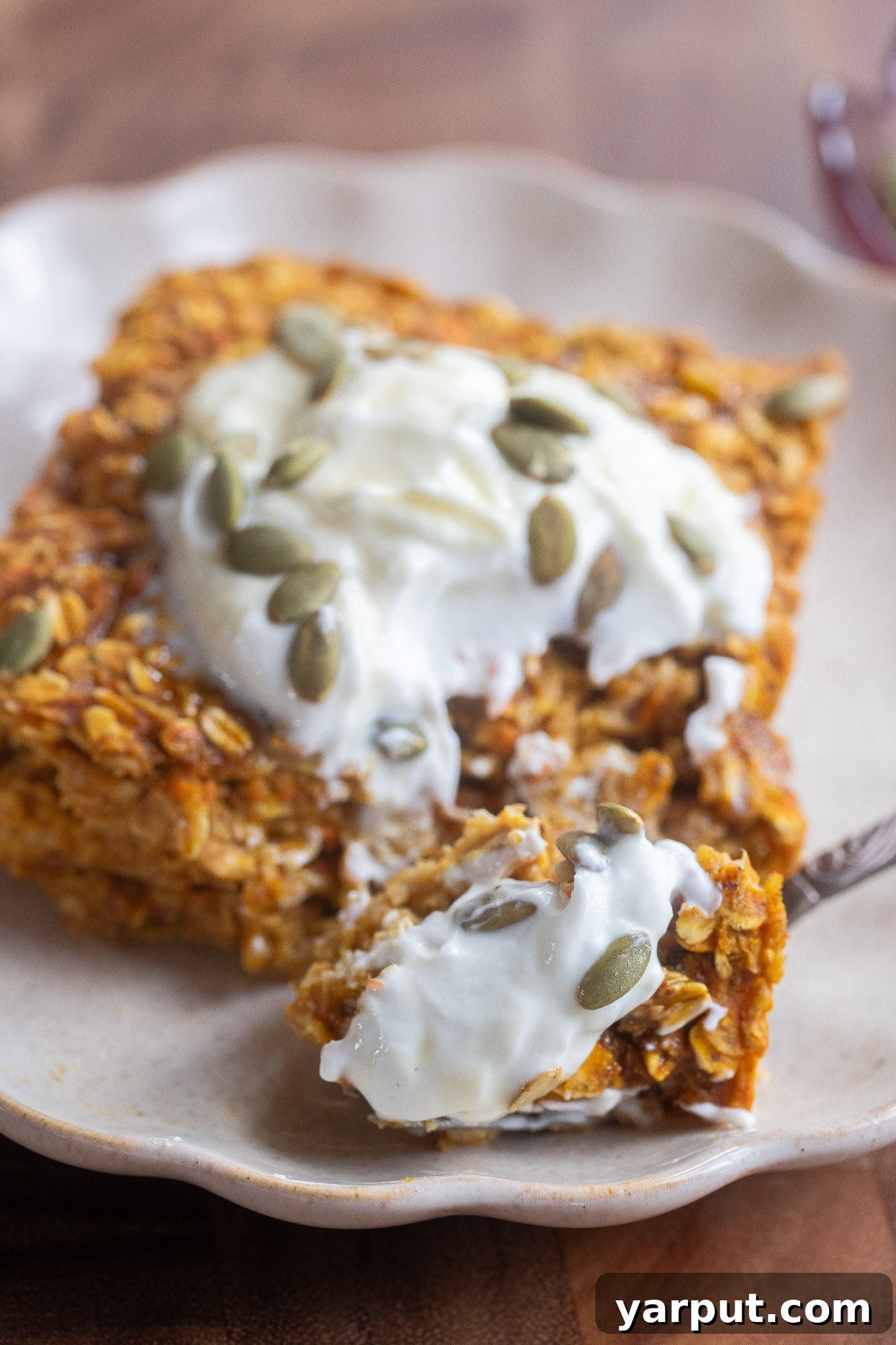 Warm Pumpkin, Ginger & Turmeric Baked Oatmeal 7 Close up of a slice of baked oatmeal with a fork and yogurt